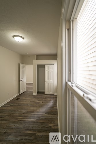 A hallway with wooden floors and white walls.