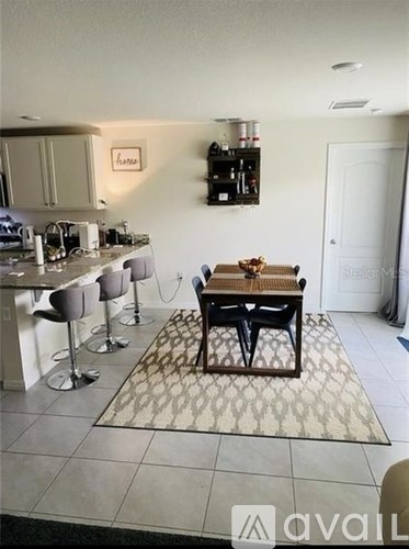 A kitchen with a dining table and chairs.