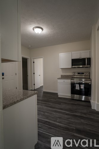 A kitchen with a granite countertop and stainless steel appliances.
