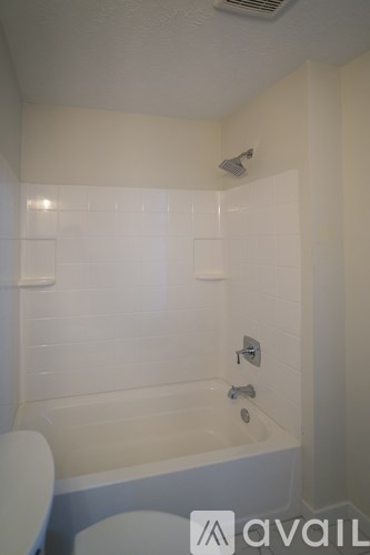 A white bathroom with a tub and toilet.