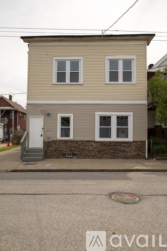 A two-story house with a beige exterior and a white door.