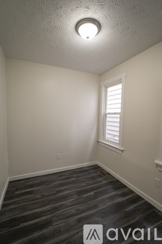 A room with a window and a wooden floor.