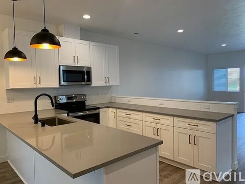 A kitchen with white cabinets and a granite countertop.
