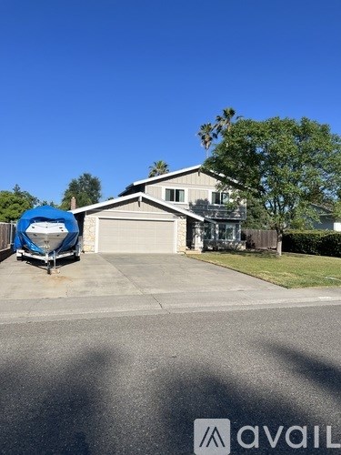 A house with a blue boat in the driveway.