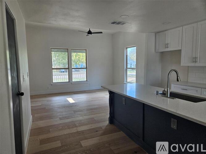 A kitchen with a wooden floor and white walls.