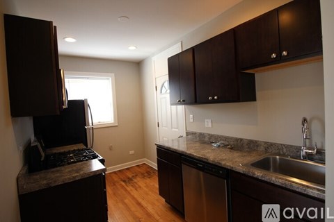 A kitchen with dark brown cabinets and a stainless steel dishwasher.