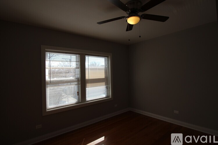 A room with a ceiling fan and a window.