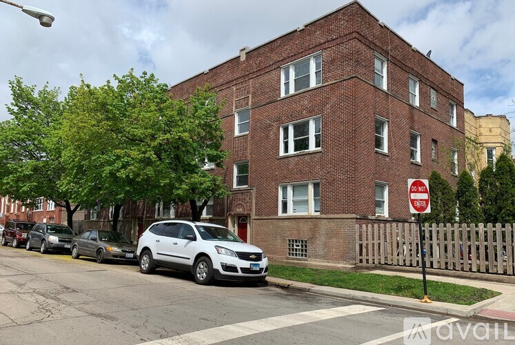 A red brick building with a white car parked in front of it.