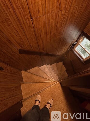 A person is standing on a wooden staircase.