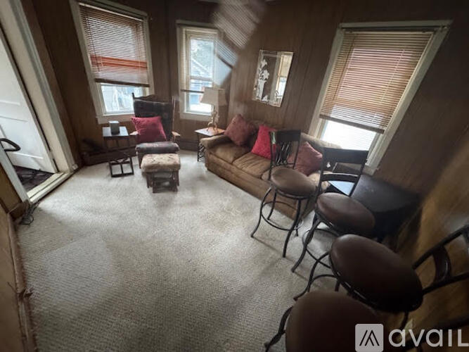 A living room with a couch, chairs, and a table.