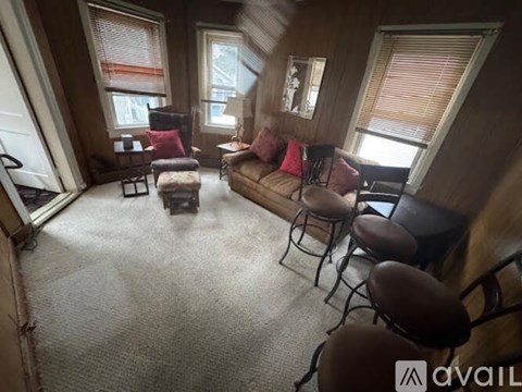 A living room with a couch, chairs, and a table.