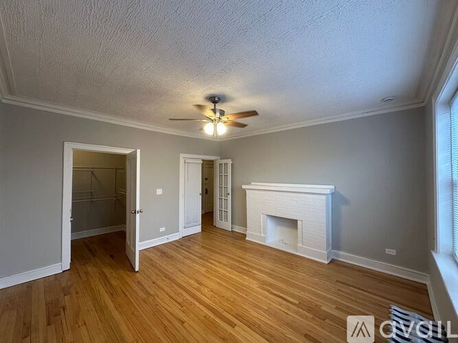 A room with a fireplace and a ceiling fan.