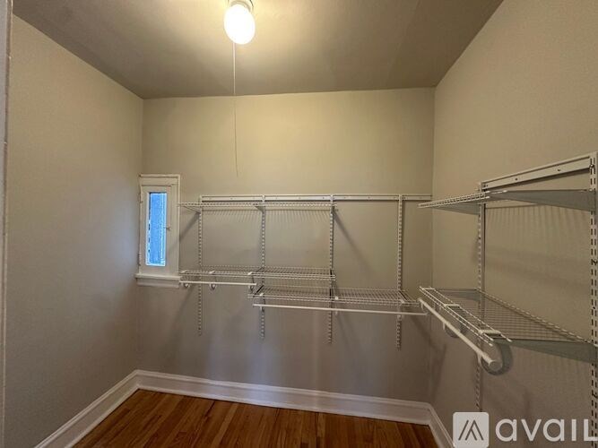 A room with a long metal shelving unit and a small window.