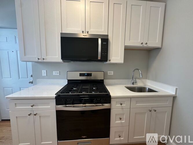 A kitchen with white cabinets and a black stove top oven.