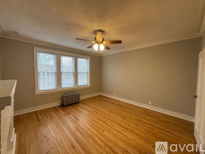 A room with wooden floors and a ceiling fan.