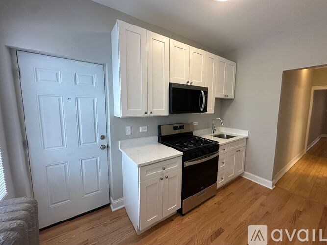 A kitchen with white cabinets and a black stove top oven.