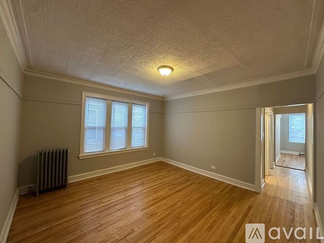 A room with wooden floors and a window with a white frame.