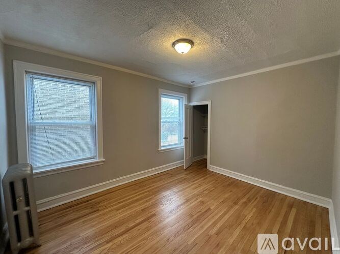 A room with wooden floors and a window with blinds.