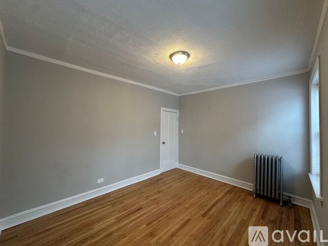 A room with wooden flooring and a white door.