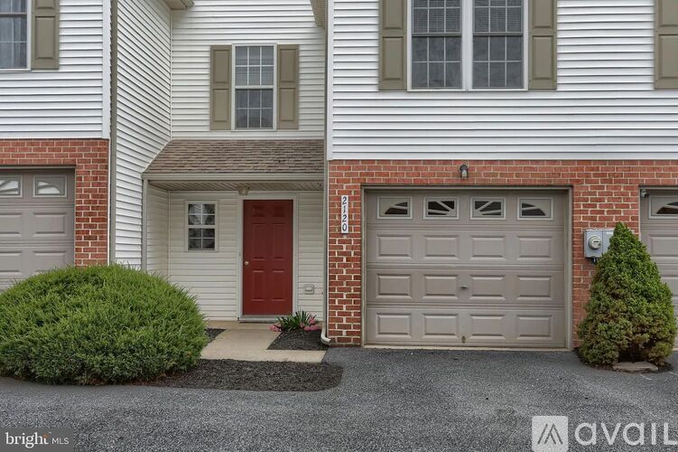 A house with a red door and a garage door.