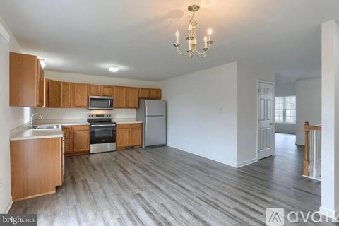 A kitchen with wooden cabinets and a grey refrigerator.