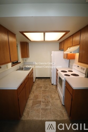 A kitchen with wooden cabinets and a white counter top.