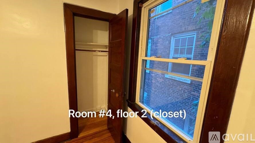 A room with a view of a brick building through a window.