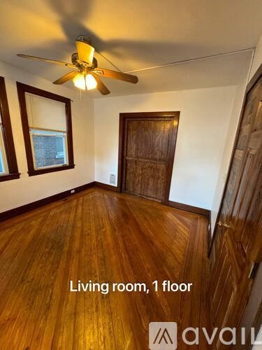 A living room with a ceiling fan and wooden floors.