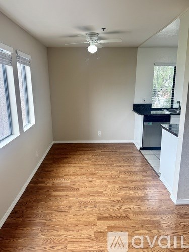 A room with wooden flooring and a ceiling fan.