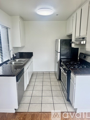 A kitchen with black countertops and white cabinets.