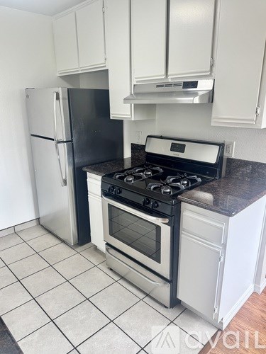A kitchen with a black stove top oven and a black refrigerator.