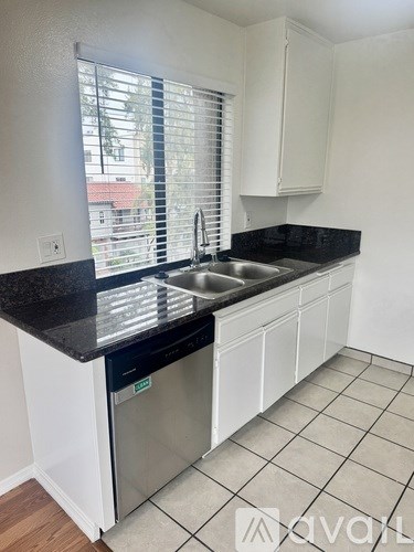 A kitchen with black countertops and white cabinets.