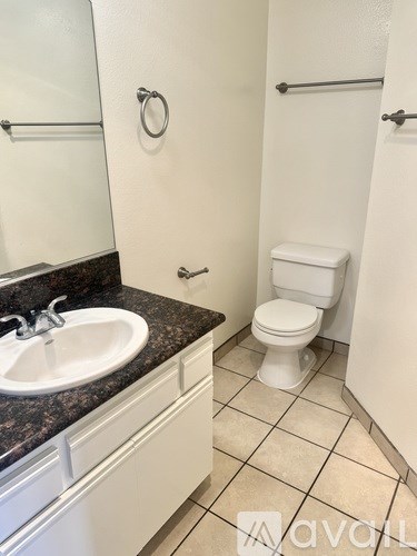 A bathroom with a toilet, sink, and mirror.
