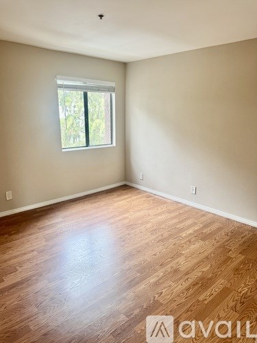 A room with wooden flooring and a window.