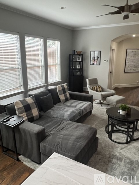 A living room with a grey couch and a black coffee table.