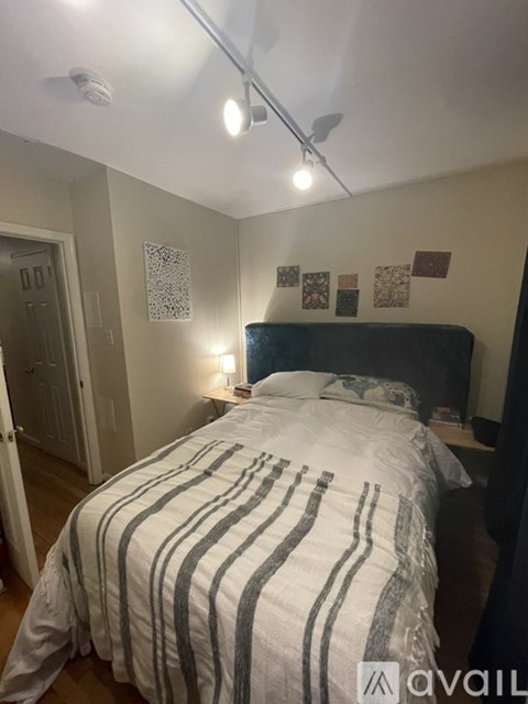 A bedroom with a bed, a nightstand, and a ceiling fan.