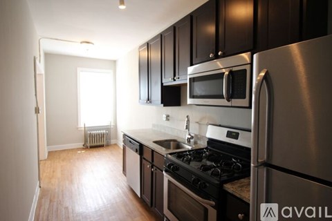 A kitchen with black cabinets and stainless steel appliances.