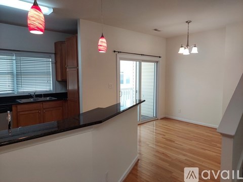 A kitchen with wooden cabinets and a black countertop.