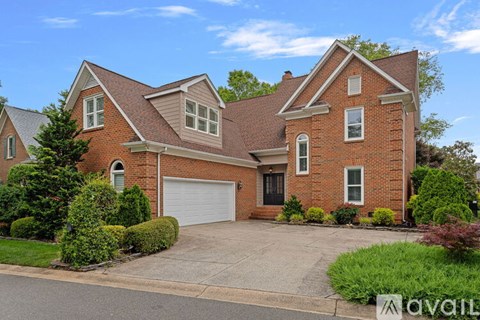 A two-story brick house with a garage is for sale.