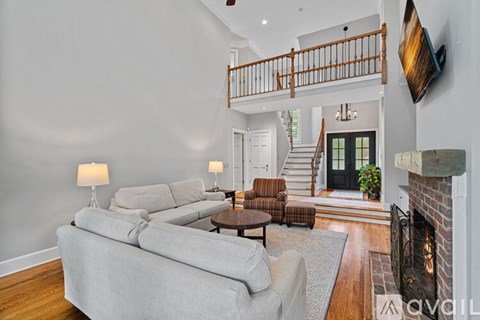 A living room with a grey couch and a fireplace.