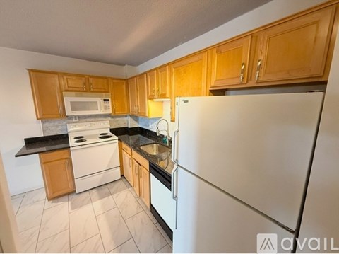 A kitchen with wooden cabinets and a white refrigerator.