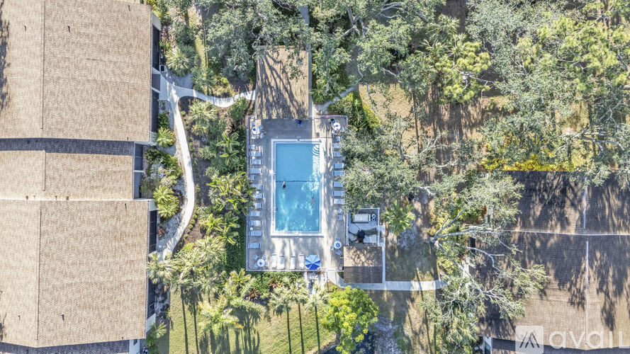 A swimming pool surrounded by trees and a building.
