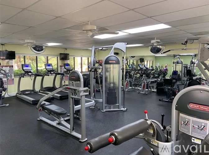 A gym with treadmills, exercise bikes, and other equipment.