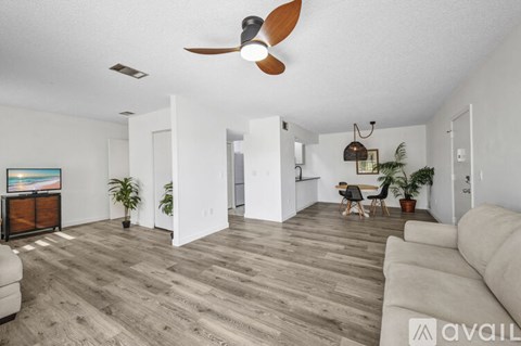 A living room with a white couch and a ceiling fan.