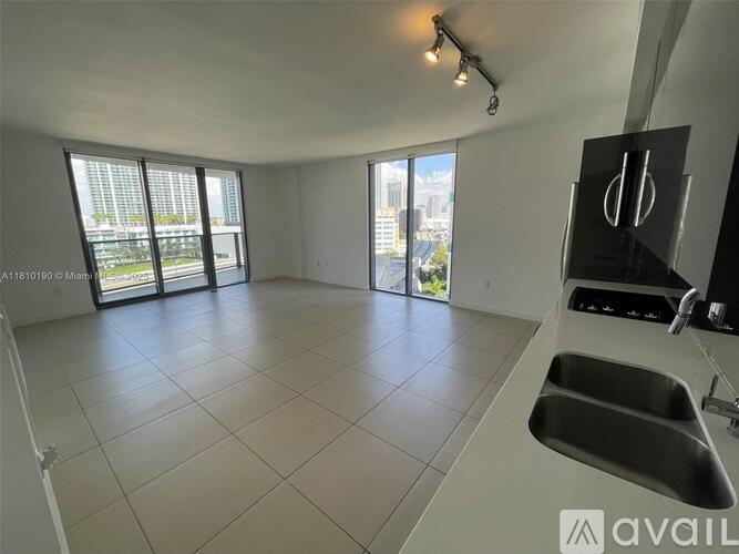 A spacious kitchen with a large island and double sinks.