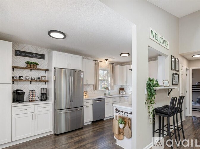 A kitchen with a refrigerator, cabinets, and a counter.