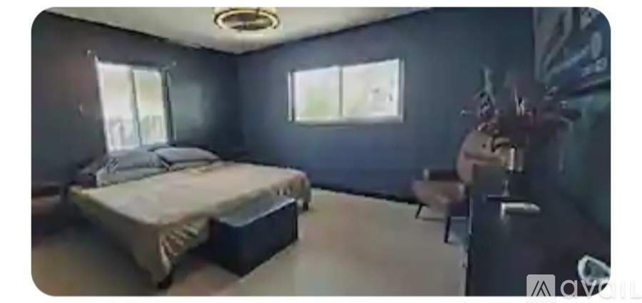 A bedroom with a bed, chair, and window.