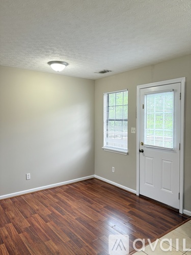 A room with a white door and a window with blinds.