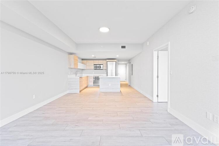A spacious kitchen with white cabinets and a central island.