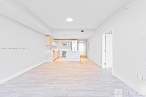 A spacious kitchen with white cabinets and a central island.